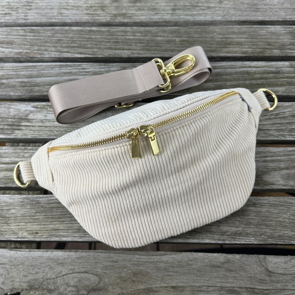 Modische Cord-Bauchtasche mit goldenem Verschluss, auswechselbarem Gurt und kompakter Form.