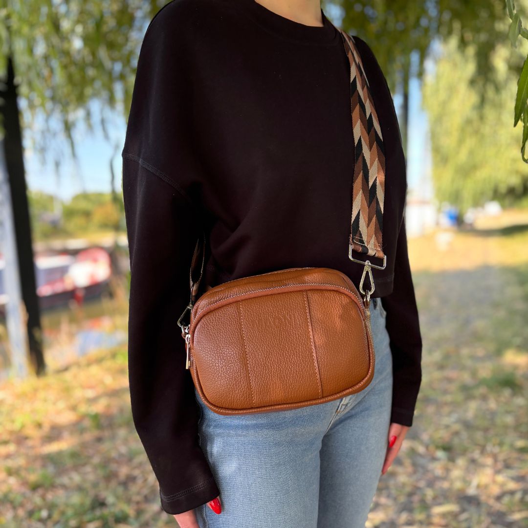 Braune Crossbody Handtasche mit Handyfach. Kombiniert mit breitem Taschengurt mit gezacktem Muster.