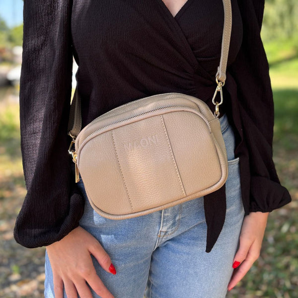 Damen-Crossbody-Tasche in sand-taupefarbener Nuance – lässig getragen als stilvolles Alltagsaccessoire