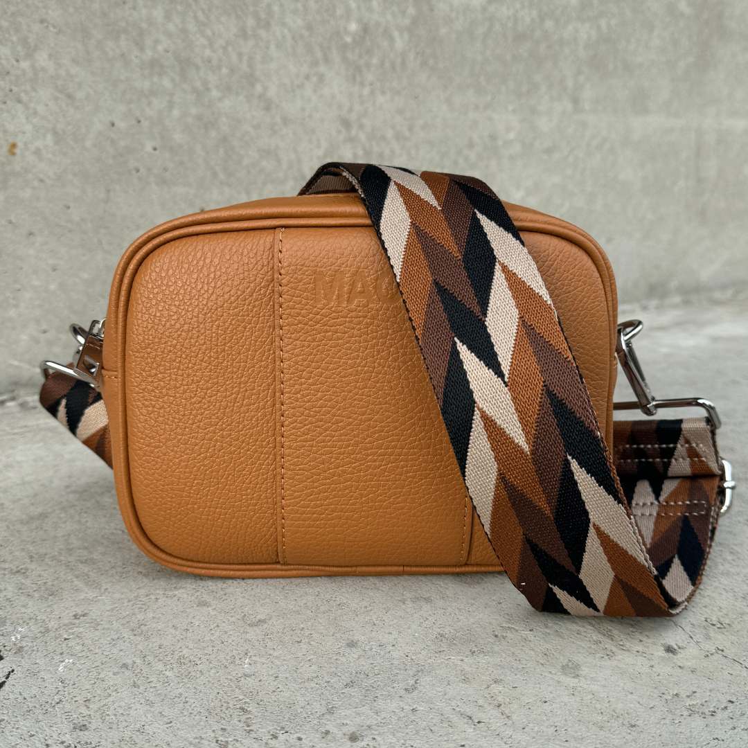 Hochwertige Crossbody-Tasche MAONI in Cognac mit silberfarbenem Verschluss – variabel durch den austauschbaren Gurt in den Farben schwarz, taupe und braun.