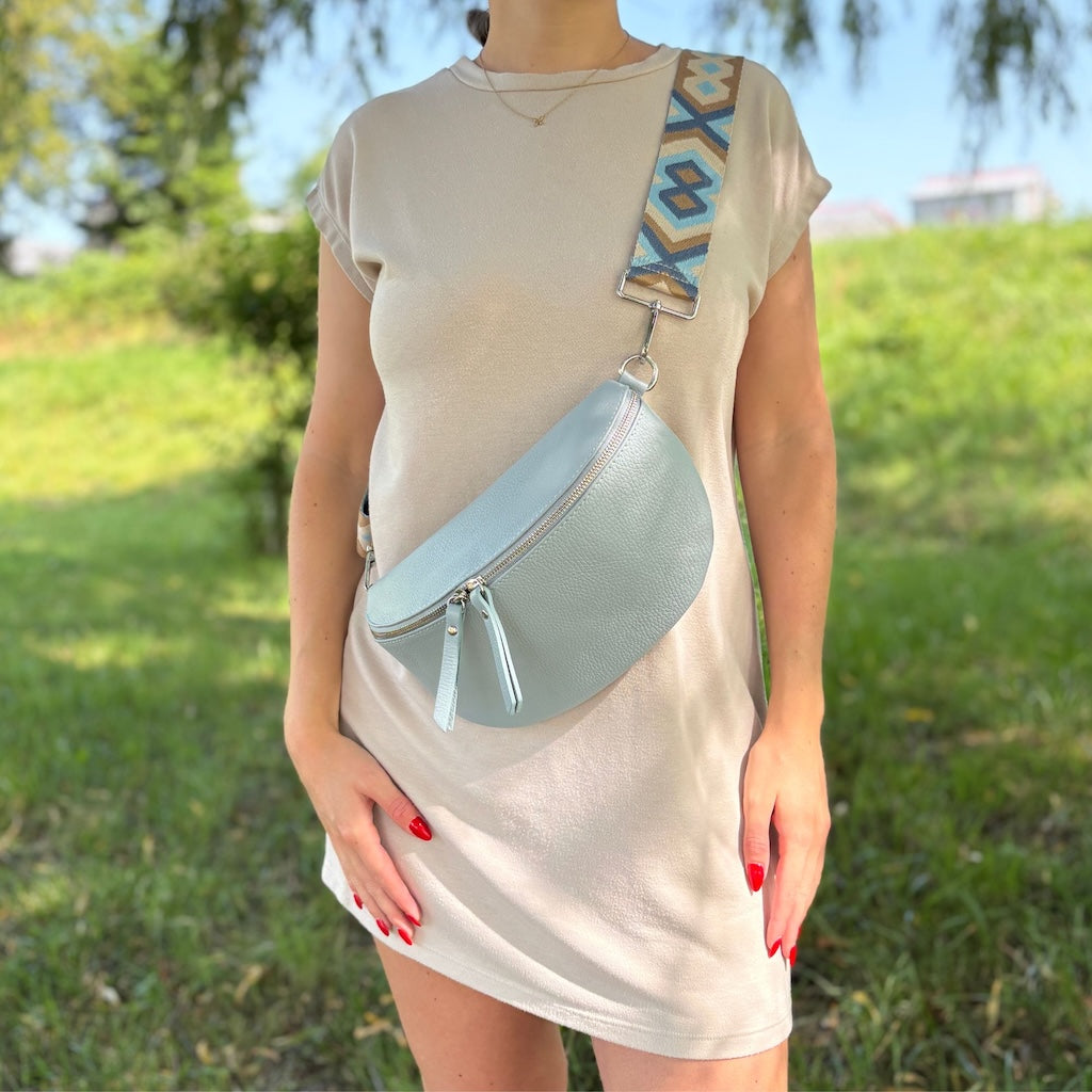 Hellblaue Bauchtasche mit auffälligem gemustertem Gurt – sommerlicher Look mit modischem Statement