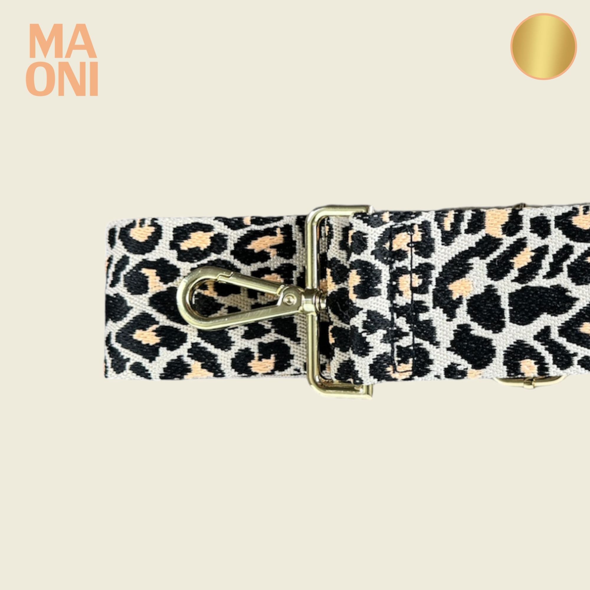 Leo-Gurt der taupefarbenen Halfmoon-Tasche auf beigem Hintergrund – modisches Detail für jedes Outfit. Die Verschlussfarbe der Hardware ist in gold gehalten.