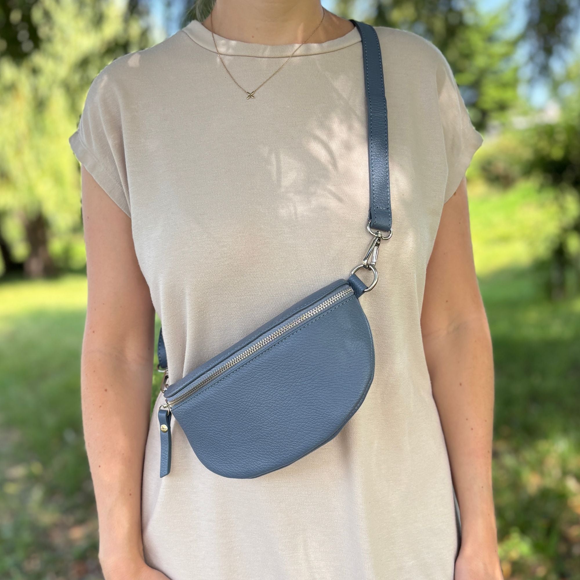 kleine Lederbauchtasche getragen von Frau in beigem Kleid