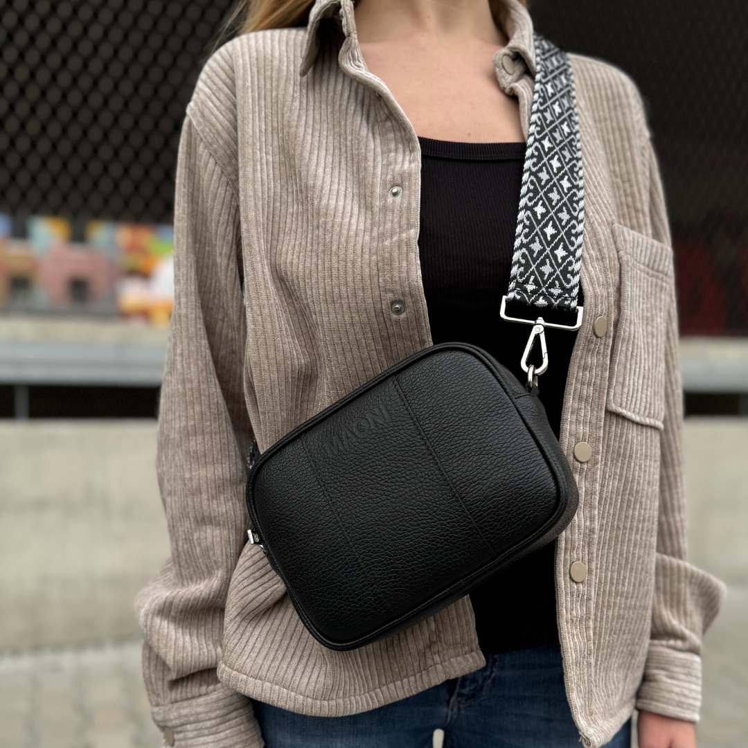 Schwarze Crossbody-Tasche MAONI mit breitem Schultergurt – modern kombiniert für einen klassischen Look.