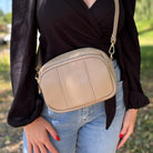 Damen-Crossbody-Tasche in sand-taupefarbener Nuance – lässig getragen als stilvolles Alltagsaccessoire