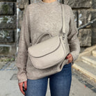 Frau trägt Halfmoon Tasche in der Farbe Grau