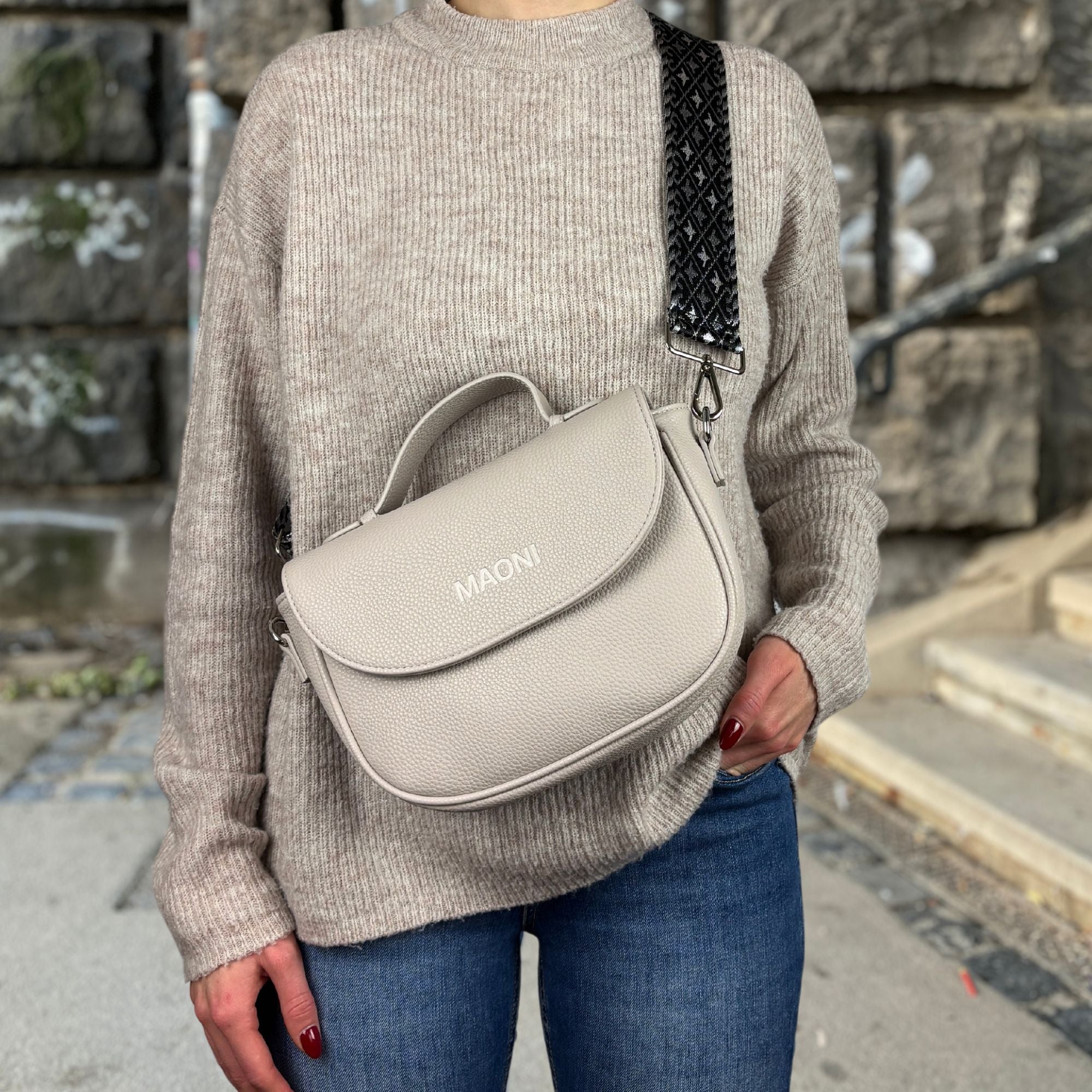 Frau trägt graue halfmoon Tasche mit schwarzem Taschengurt