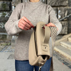 Frau öffnet Reißverschlussfach auf der Rückseite von Halfmoon Tasche 