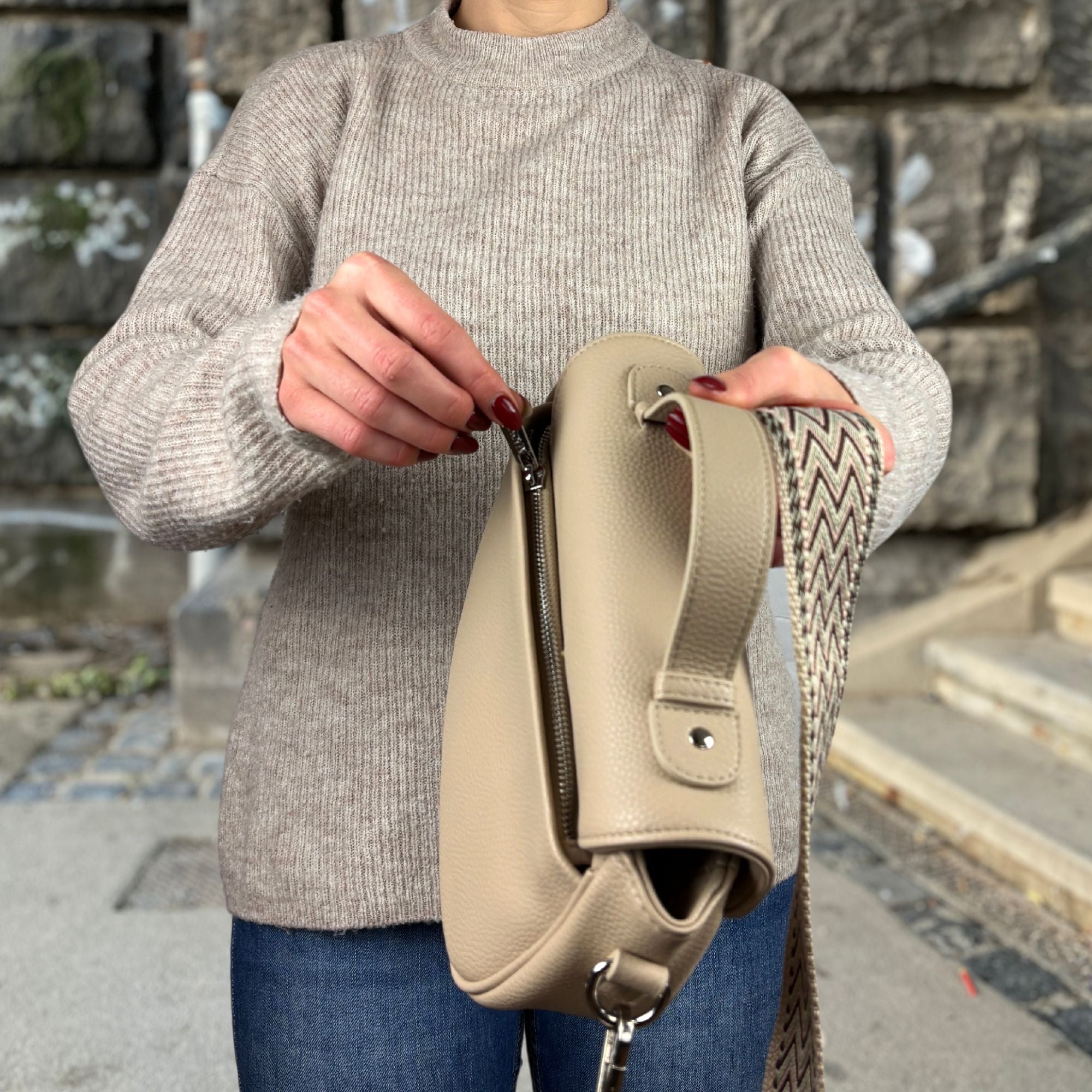 Frau öffnet Reißverschlussfach auf der Rückseite von Halfmoon Tasche 