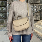 Frau trägt Half Moon Bag in der Farbe taupe